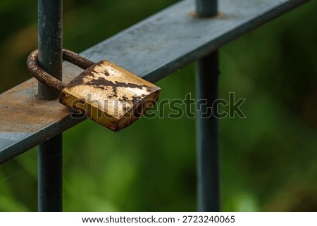 A rusty padlock hangs on the gate