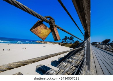 Rusty Padlocks "Love Locks" Attached to Cable on a Sunny Beach Boardwalk Day - Powered by Shutterstock