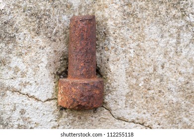 Rusty part of a hinge in an concrete wall