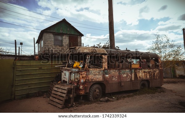 Сollapsed,\
rusty, scary bus in the middle of\
slums.