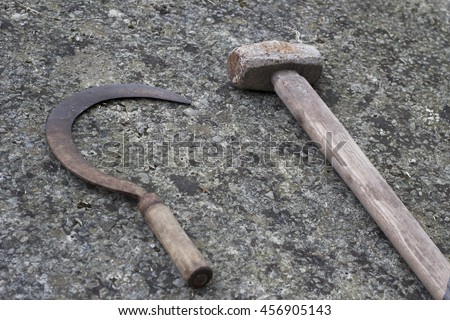 Rusty sickle and hammer on the pavement. Communism concept.