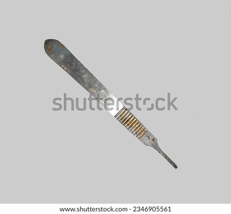 rusty stainless steel scalpel handle on gray background. scalpel handle or knife handle is one of the tools used during a surgical operation to hold a knife or scalpel.