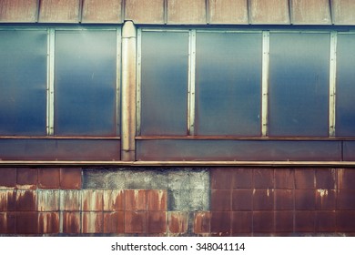 Rusty tile wall with windows. Abstract industrial background. Railway station. Vintage effect. 