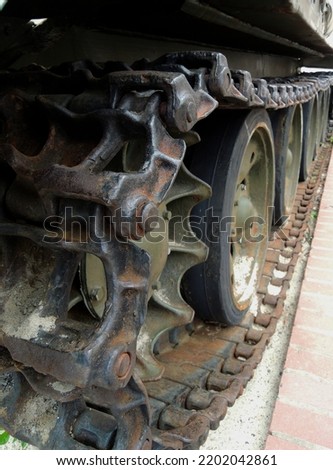 Rusty tracks of a crawler military armored carrier vehicle closeup photo for a vertical story
