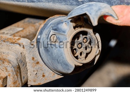 Rusty trailer hitch connection with exposed electrical wiring.