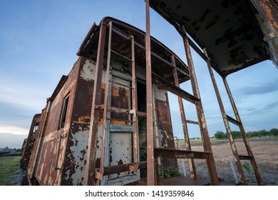 Rusty train cabin and cargo container is abandoned at outdoor yard with blue sky background. Selected focus photo.