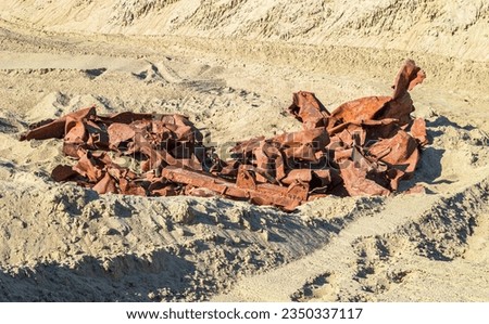 Rusty Twisted Metal Structures Lying on the Sand