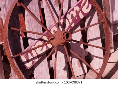 Rusty Wagon Wheel Over A Welcome Sign