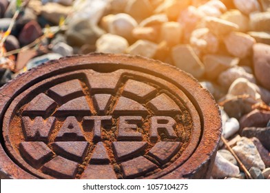 rusty water supply lid on ground with sunlight effect, steel water pipeline system, underground infrastructure
