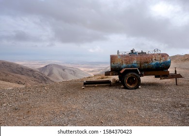 Rusty Water Tanker Truck Placed On The Side Of The Gravel Road In The Desert, Near Jericho City. West Bank