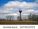 A rusty water tower standing in the field of the old dairy farm used by the Indiana state Hospital for the insane just outside logansport indiana                              