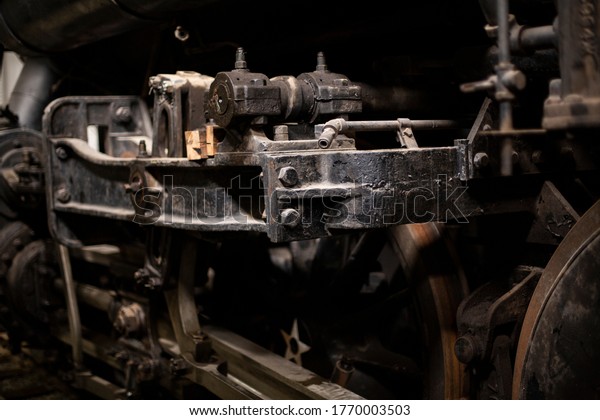 Rusty\
wheels and mechanisms of an antique steam\
engine