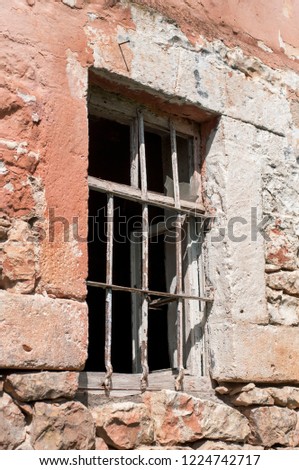 Rusty window grille and old block brick wall
