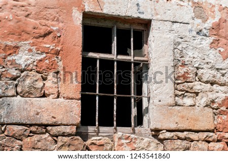 Rusty window grille and old block brick wall