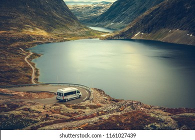 RV Camper Scenic Road Trip. Raw Norwegian Landscape And The Camper Van Recreational Vehicle On The Winding Mountain Road Near Famous Village Of Geiranger.