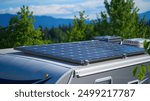 RV camping in nature and portable solar photovoltaic panels on camper van. Holiday trip in motor home.