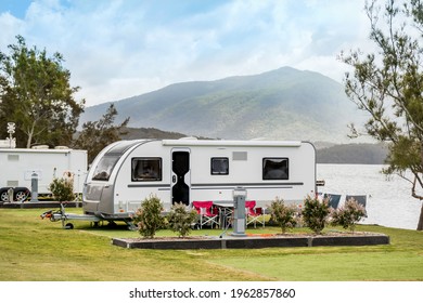 RV Caravan Camping At The Caravan Park On A Peaceful Lake With Mountains On The Horizon. Camping Vacation Family Travel Concept
