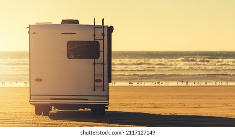 RV Class C Motorhome Camper Van Camping on a Sandy Beach. Oceanfront Wild Camping. - Shutterstock ID 2117127149