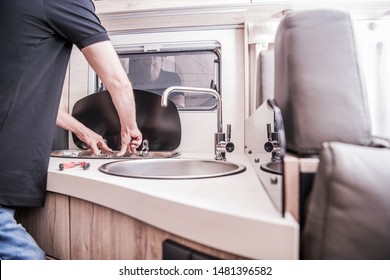 RV Motorhome Broken And Propane Leaking Stove Repair. Caucasian RV Technician Servicing Broken Stove Inside Modern Travel Trailer. Cooker Problem.