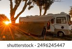 Rv motorhome camping with trees and sunburst with awning out on rv