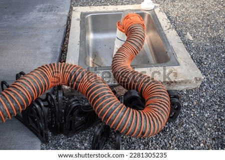 RV, motorhome or trailer, recreational vehicle sewer dump hose runs to a drain station.
