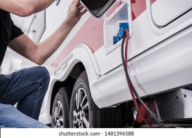 RV Park Electric Hookup. Caucasian Men in His 40s Connecting His Travel Trailer Recreational Vehicle to Park Electric Installation. - Shutterstock ID 1481396588