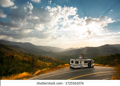 RV Road Trip. Young People Enjoy Freedom And An Epic Nature Mountain View From The Roof Top Of An RV Motorhome. Traveling Lifestyle Roadtrip Adventure In The USA