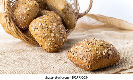 Rye bread. Bakery with crusty loaves and crumbs. Fresh loaf of rustic traditional bread with wheat grain ear or rye spike plant on natural cotton background. Healthy Food concept