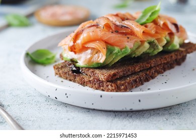 A Rye Bread Sandwich With Avocado And Salmon