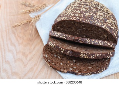 Rye bread with seeds on wooden background, cutout. Whole grain healthy meal
