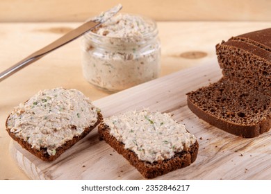 Rye bread slices generously topped with delightful mix of pate, eggs and chives creating mouthwatering display on wooden background