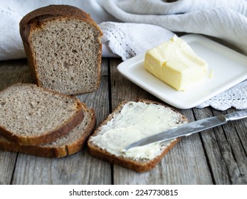 Rye bread and some butter to spread on the slices. Close up. Horizontal, rustic. - Shutterstock ID 2247730815