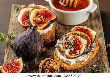 Rye bread toast with figs and ricotta cheese on a wooden board. Food recipe background. Close up.