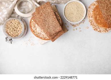 Pan de centeno, pasteles de arroz y galletas sobre mesa blanca, puesta plana. Espacio para texto