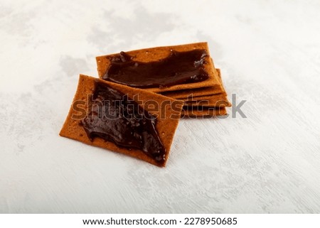 Rye crisps with thick Australian spread made from leftover brewers yeast extract, selective focus. Aussie savory chips with vegemite. Vegemite is a very popular yeast based spread in Australia.