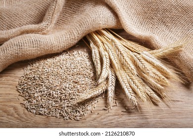 Rye grains and ears on wooden table, top view - Shutterstock ID 2126210870