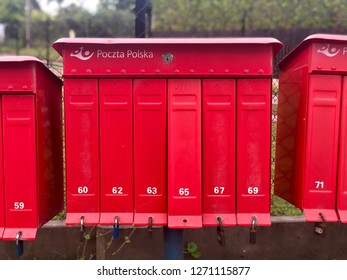 RZESZOW, POLAND - August 18, 2018: Bright Red Outdoor Cluster Mail Boxes With Individual Slots In Rural Poland. The Text In Polish On The Mail Box Translates To: 'The Post Office Of Poland'.
