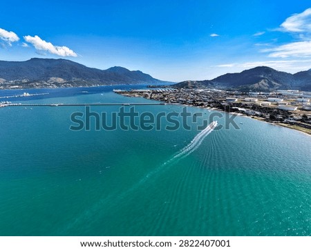23° 46′ 28″ S de latitude e 45° 21′ 20″ O de longitude High angle drone shot of turquoise sea and coastal landscape in Ilhabela channel with boats sailing on a sunny day.
