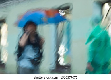 It 's raining hard, through the window. Blurred silhouettes of people in the city go about their business