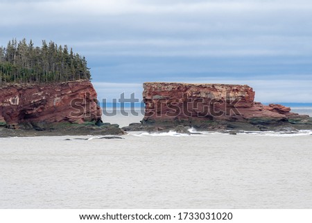 S sea stack formed in red sandstone by erosion. Located near St. Martins New Brunswick in the Bay of Fundy.