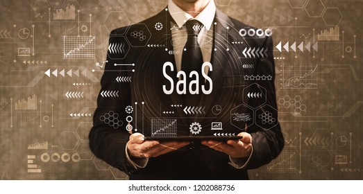 SaaS with businessman holding a tablet computer on a dark vintage background