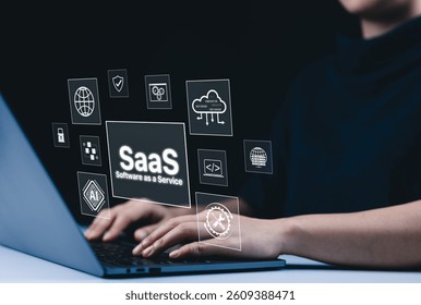 SaaS Cloud Computing and Software as a Service Concept. A person using a laptop with virtual interface icons showing SaaS, cloud computing, AI, and software integration. modern technology platforms,
