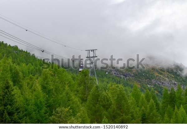 Saas Fee,\
Switzerland - September 25, 2019: Alpin Express ropeway lift\
transporting visitors back down to the\
valley.
