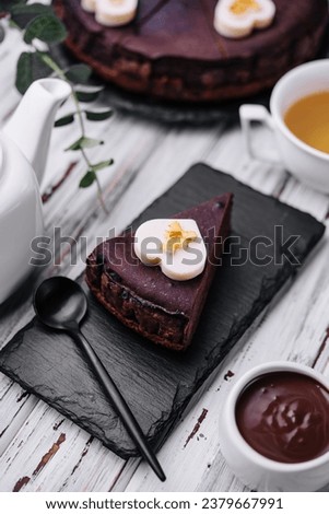 Sacher cake slice and tea on wood