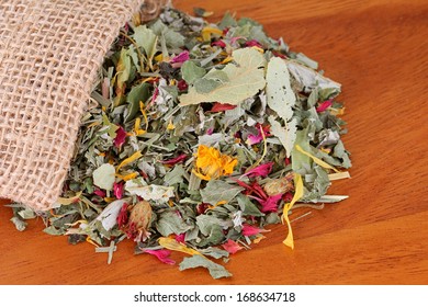 A Sack Of Dried Herbal Tea With Flowers On A Wooden Background. It Consists Of Lemon Balm, Rose Petal, Marigold, Cornflower, Blackberry, Lemongrass Leaves With Antioxidant Benefit