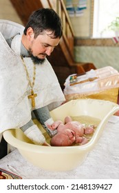 the sacrament of the baptism of a child. baptism in the Orthodox Church. Bathing in holy water. Ukrainian church and a priest with a baby