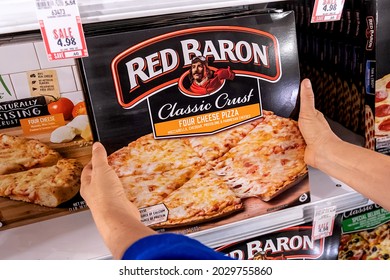 Sacramento, CA, USA August 20th, 2021. Shoppers Hand Holding A Package Of Red Baron Four Cheeses Frozen Pizza In A Supermarket Aisle