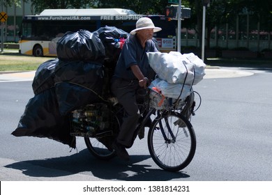 Sacramento, California / USA - May-09-2015 Editorial image of a man on a bicycle overloaded with can and bottles heading to a recycle center to cash in.