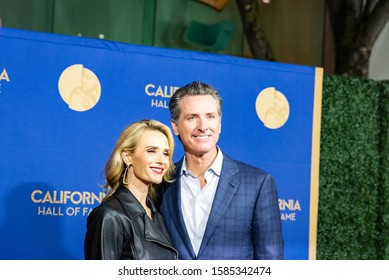 SACRAMENTO, CA/U.S.A. - DECEMBER 10, 2019: Horizontal Photo Of California Governor Gavin Newsom With His Wife Jennifer Siebel Newsom, At The Red Carpet Event At The Hall Of Fame Inductees Event.