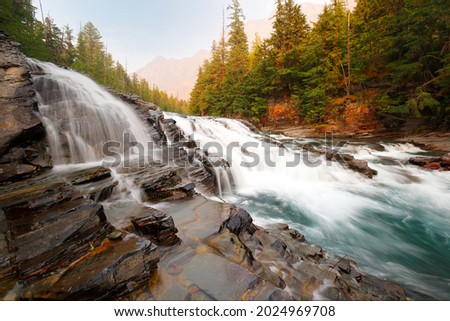 Sacred Dancing Cascade at sunset, Glacier National Park. Sacred Dancing Cascade is a water falls in Glacier National Park and is located in Flathead County in the U.S. state of Montana